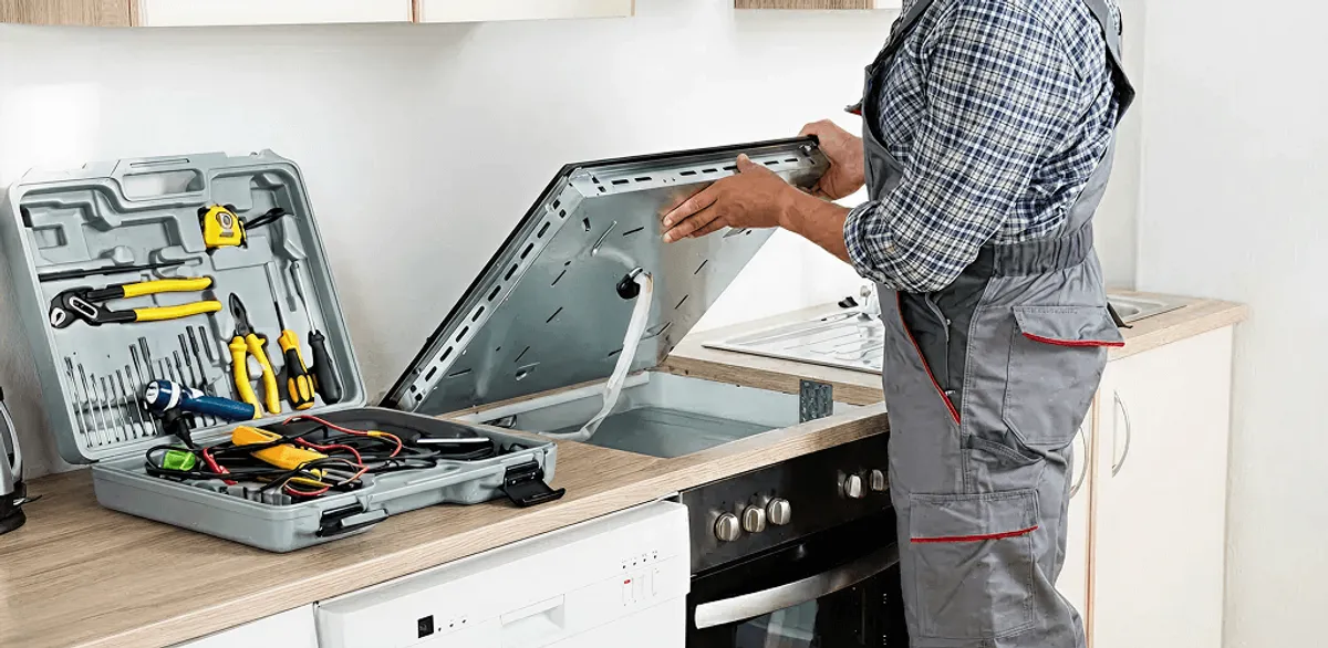 Handyman repairing a cooktop and checking wiring connections in Las Vegas, NV