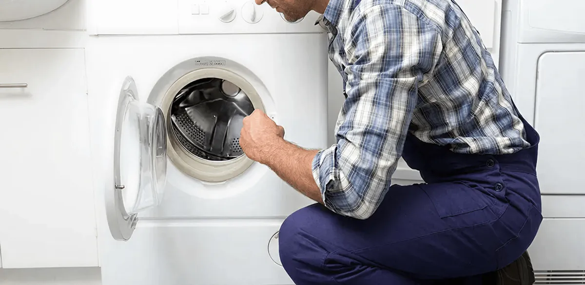 Handyman inspecting a dryer drum and internal parts for repair in Las Vegas, NV