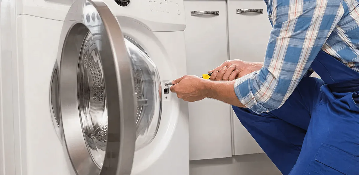 Handyman repairing a clothes dryer and checking electrical connections in Las Vegas, NV