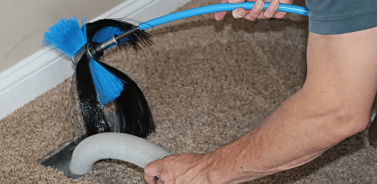 Dryer vent cleaning technician brushing lint from a vent line in Las Vegas, NV