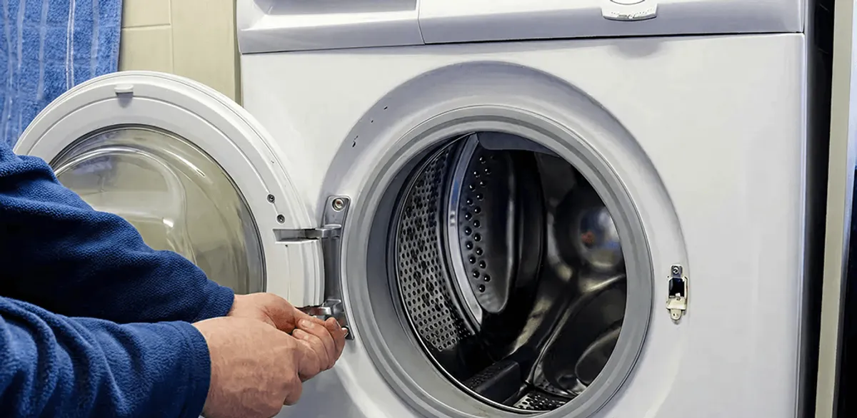 Washing machine repair handyman checking a front-load washer door and latch in Las Vegas, NV